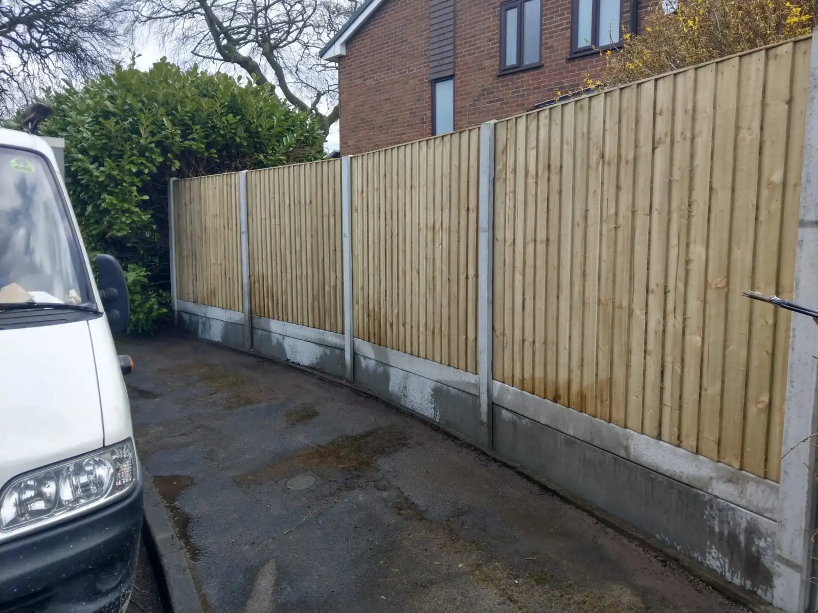 Long run of close-board fencing with concrete posts and gravel boards