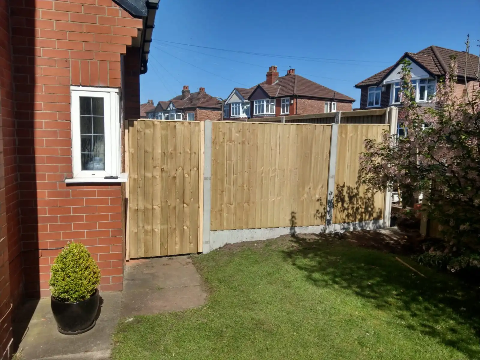 Wooden side gate with ring handle fitted between brick walls