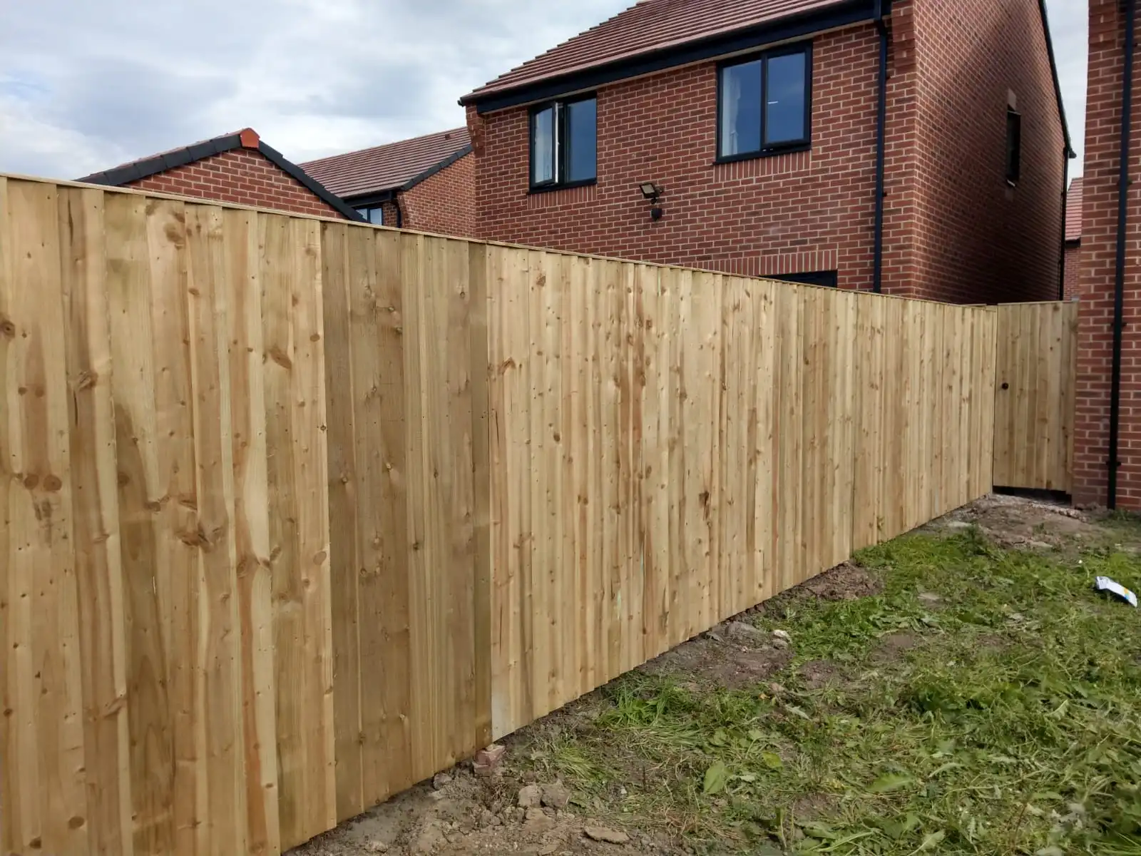 Tall vertical close-board fencing installation along driveway in Altrincham